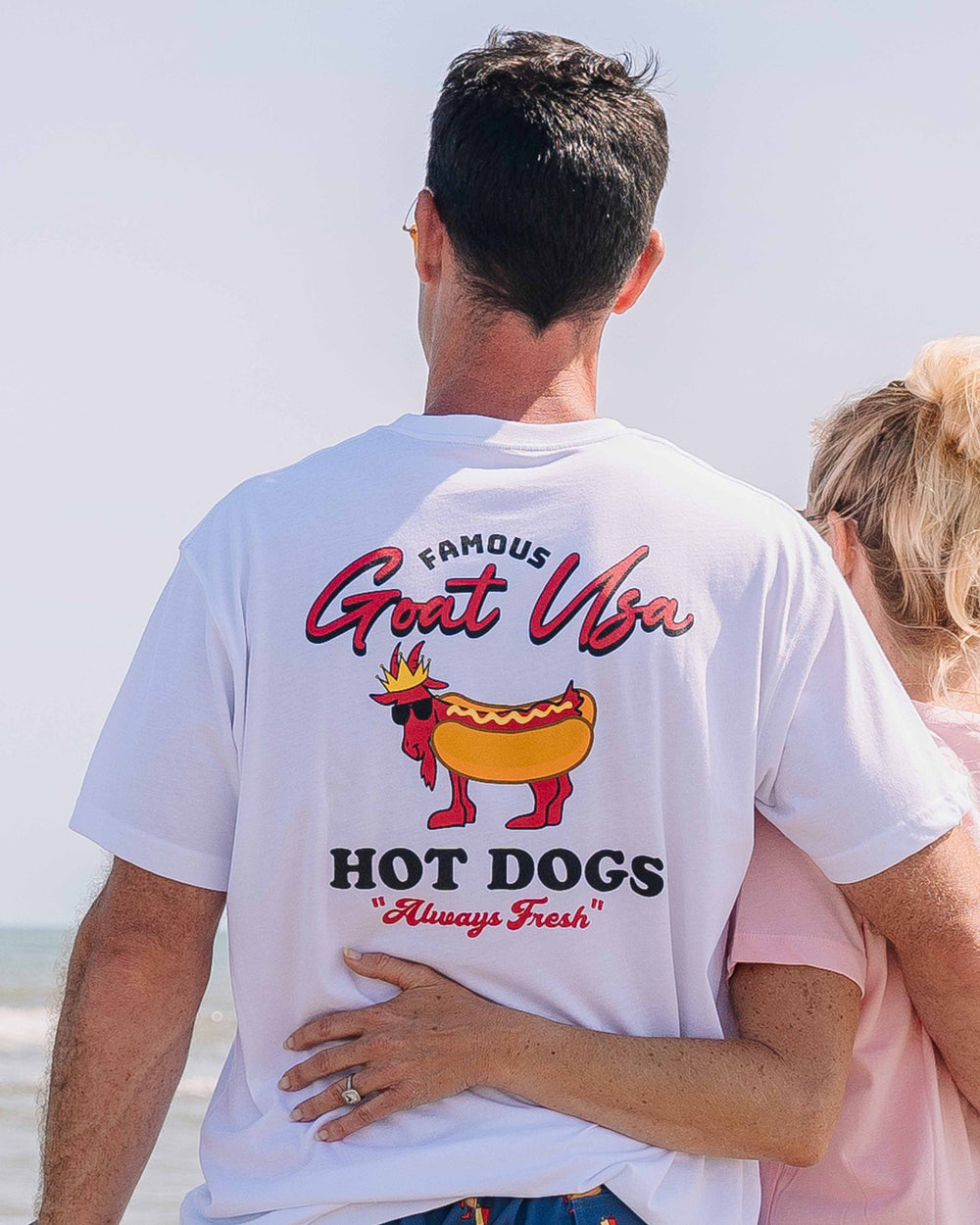 Wife with hand around husband looking out at the ocean